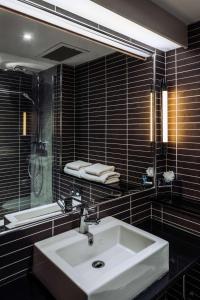 W łazience znajduje się biała umywalka i lustro. w obiekcie pentahotel Reading w mieście Reading