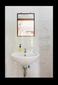 ein weißes Waschbecken im Bad mit Spiegel in der Unterkunft Artja Inn Ubud in Ubud