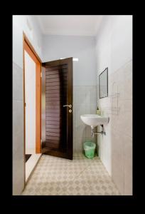 een badkamer met een wastafel, een spiegel en een toilet bij Artja Inn Ubud in Ubud