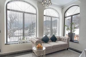 a living room with a couch and large windows at Oana Boutique CDI in Bran +72 photos
