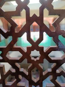 une fermeture d’un motif en bois sur un mur dans l'établissement marrakesh riad, à Marrakech