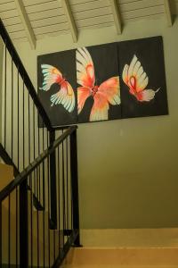 una escalera con dos pinturas de flores en la pared en Hiru Beach Resort, en Kalpitiya