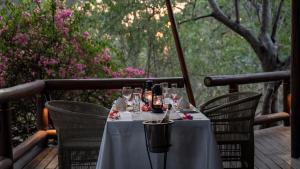 einen Tisch mit Weingläsern auf dem Deck in der Unterkunft Tuli Safari Lodge Mashatu in Lentswelemoriti