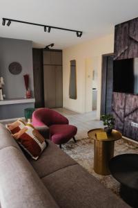 a living room with a couch and a tv at RIVA Boutique Hotel in Szeged