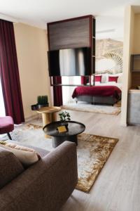- un salon avec un canapé et un lit dans l'établissement RIVA Boutique Hotel, à Szeged