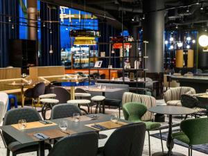 a dining room with tables and chairs and tablesktop at TRIBE Budapest Stadium in Budapest