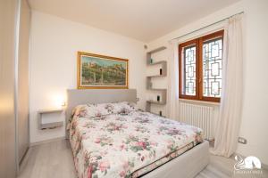a bedroom with a bed with a floral bedspread at Appartamento Giada in Padenghe sul Garda +40 photos