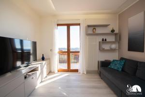 a living room with a couch and a flat screen tv at Appartamento Giada in Padenghe sul Garda