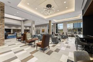 a restaurant with a lobby with chairs and tables at Embassy Suites By Hilton Irving Las Colinas in Irving