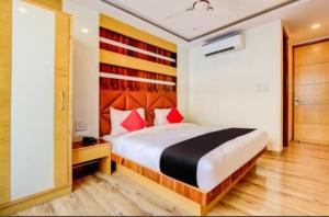 a bedroom with a large bed with red pillows at The New Lord Krishna @ New Delhi Railway station in New Delhi