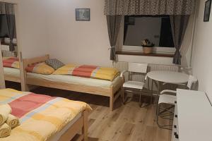 - une chambre avec 2 lits, une table et des chaises dans l'établissement Apartmá Adam, à Rokytnice nad Jizerou