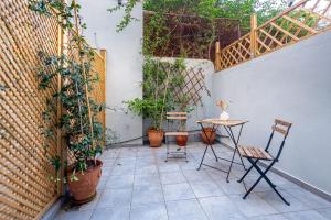 une terrasse avec une table, des chaises et des plantes en pot dans l'établissement Phaedrus Living: The Nine Muses Polymnia, à Athènes
