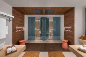 a bathroom with a shower with blue glass at Hilton Cancun Mar Caribe All-Inclusive Resort in Cancún
