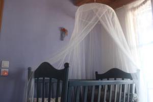 a nursery with two cribs and a veil over a window at The Light Blue House in Karavostamo