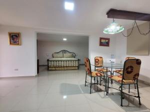 sala de estar con mesa, sillas y cama en Hotel Olimpo en La Romana