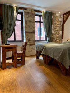 a bedroom with two beds and a table and two windows at Pension Westerhuesen in Magdeburg