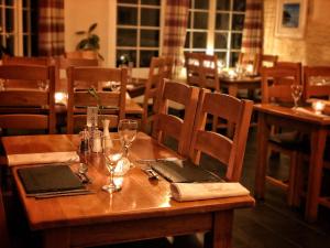 una mesa de madera en un restaurante con sidx de mesa en The Riverside, en Boscastle