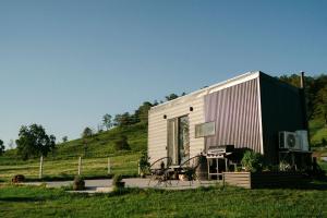 a tiny house sitting on top of a field at Wildflower On The Rocks in Rock Valley