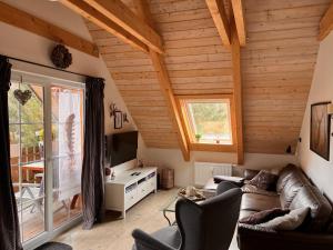 uma sala de estar com tectos em madeira e uma grande janela em Ferienwohnung Hexenstube 1 em Tanne