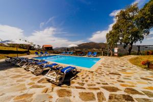 una piscina con sedie a sdraio accanto al resort di Cabana Oliveira a Castelo de Paiva