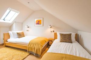 a attic bedroom with two beds and a window at Starboard Light in Whitstable