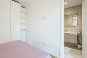 a bedroom with a pink bed and a bathroom at Luna di mare - nuovo appartamento sul mare in Acireale +35 photos