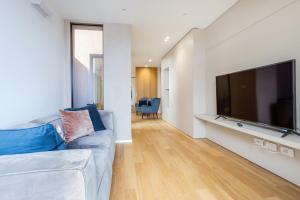 a living room with a couch and a large television at Luna di mare - nuovo appartamento sul mare in Acireale