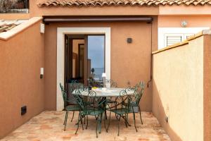 a patio with a table and chairs on a balcony at Luna di mare - nuovo appartamento sul mare in Acireale