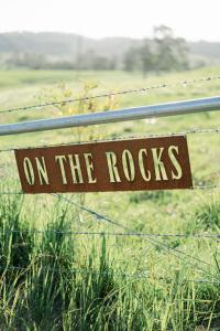 een bord op een hek dat leest op de rotsen bij Whisky @ On The Rocks 