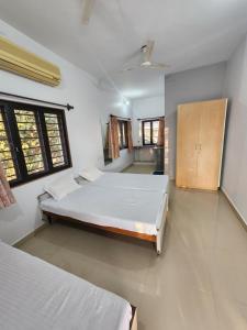 ein großes Schlafzimmer mit 2 Betten und einem Schrank in der Unterkunft Amrutiya Farm in Bhuj