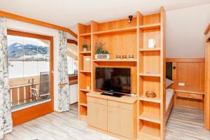ブルクベルクにあるMein Landhausのリビングルーム(木製の棚、テレビ付)