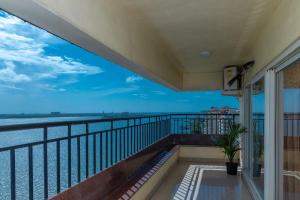 een balkon met uitzicht op het water bij Best sea view serviced apartments at marine drive cochin in Cochin