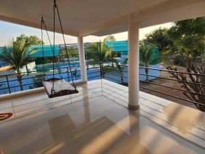 einen Balkon mit einer Schaukel und Blick auf das Wasser in der Unterkunft Amrutiya Farm in Bhuj