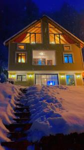 a house in the snow at night at Nanus Ayder Bungalow and Breakfast in Çamlıhemşin