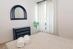 a bedroom with a bed and a dresser and a window at TAC - Vilamoura Center in Vilamoura