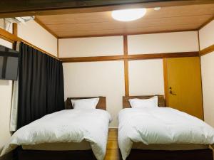 two beds sitting next to each other in a room at 東京昭島迎賓館 in Akishima