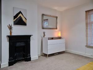 a room with a fireplace and a dresser and a mirror at Grange Lane in Manchester