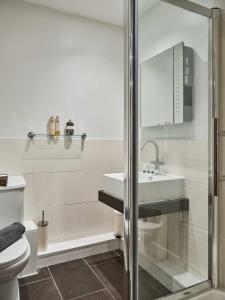 La salle de bains blanche est pourvue d'un lavabo et de toilettes. dans l'établissement Grange Lane, à Manchester