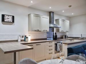 a kitchen with white cabinets and a table with wine glasses at Grange Lane in Manchester