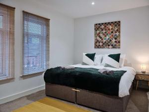 a bedroom with a large bed and two windows at Grange Lane in Manchester