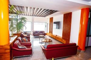 una sala de estar con 2 sofás rojos y una mesa. en Vedoko appart'hotel, en Cotonou