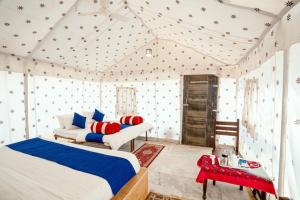 um quarto com 2 camas e uma mesa vermelha em Excellent Desert Safari camp em Sām