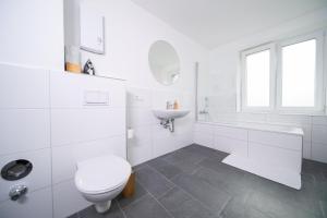 a white bathroom with a toilet and a sink at Stylish Apartments - 71 m² - Zentral - 10 Min Messe in Düsseldorf