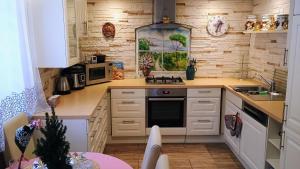 a kitchen with white cabinets and a christmas tree in it at Ubytování v soukromí Karin in Ludvíkov