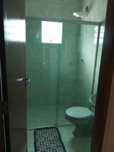 a bathroom with a toilet and a glass shower at Vista da Serra in Cavalcante