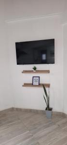 a room with a tv and a clock on a wall at Departamentos Muy Eugenia in San Rafael +9 photos