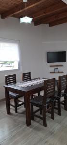 a dining room table with chairs and a television at Departamentos Muy Eugenia in San Rafael