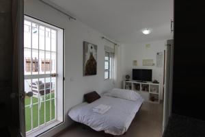 Cama en habitación con ventana en RentalSevilla terraza privada junto al Guadalquivir, en Sevilla