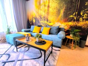 una sala de estar con un sofá azul y una pintura en 6 Luxury SPA Apartments TOP resort Bansko - incl wellness, en Bansko
