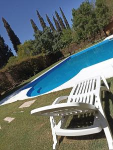 a white chair sitting next to a swimming pool at Cabaña sol y campo in Guaymallen